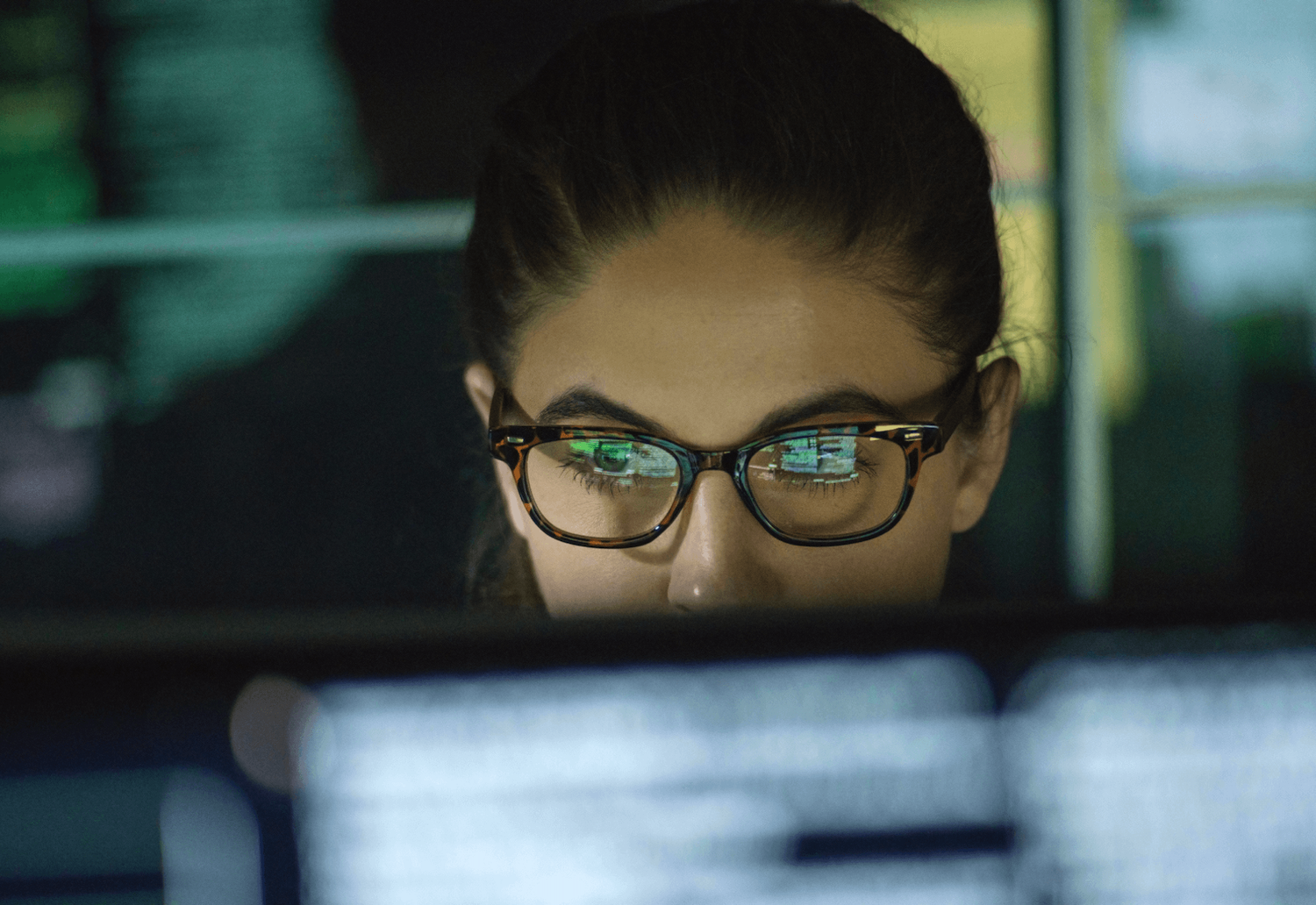 woman looking at computer screen through glasses